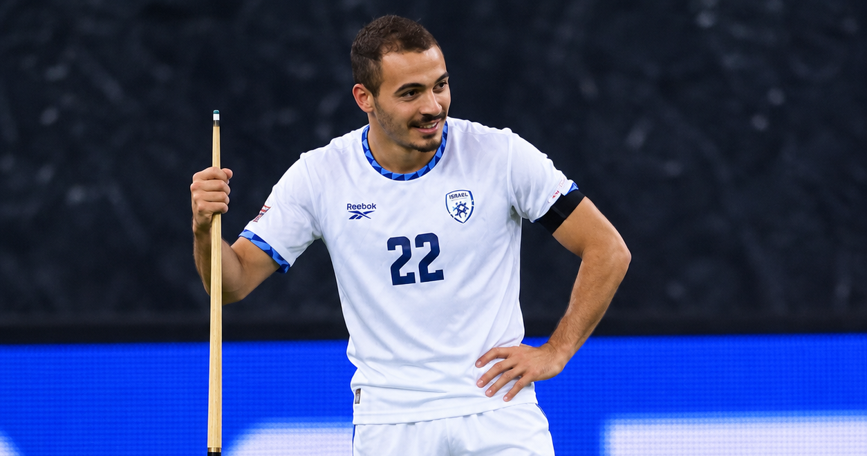 Sayed Abu Farchi holding a snooker cue during a football celebration